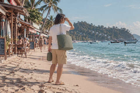 Sonny arriving at a tropical beach wearing OGL work pocket T-shirt in white and OGL Tropical Ripstop shorts in khaki, carrying OriGinaLe Millie Carry-All Tote Bag in green