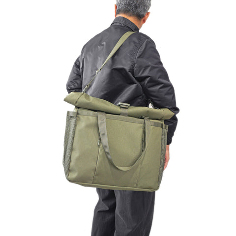 Model shoulder carry OriGinaLe Origo Roll-Top Tote Bag in olive technical canvas in Rugged Gentlemen Shoppe Singapore