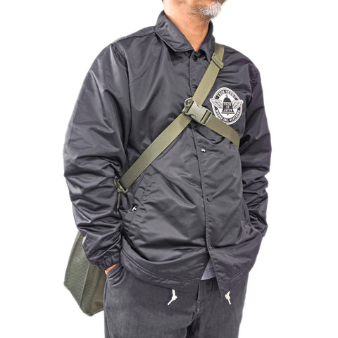 Model cross-body carry of OriGinaLe Origo Roll-Top Tote Bag in olive technical canvas with cros-body stabilizer in Rugged Gentlemen Shoppe Singapore