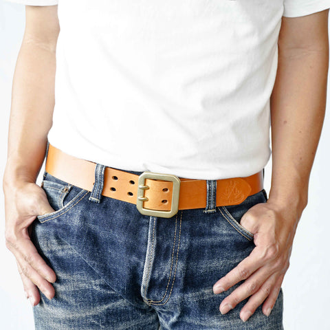 Model wearing OGL Double-Prong Garrison Belt Natural handmade full-grain leather solid brass double-prong buckle in faded raw denim