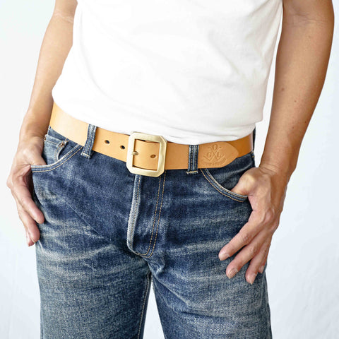 Model wearing OGL Single-Prong Garrison Leather Belt Natural – Full-Grain Leather with solid brass buckle in faded raw denim