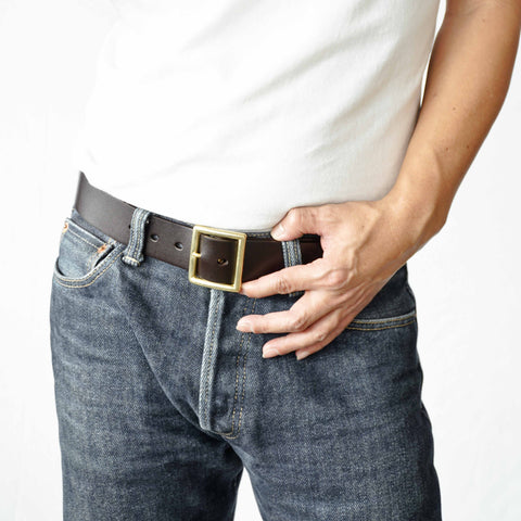 Model wearing OGL Vintage 1.5 Leather Belt Full-Dyed Brown handmade full-grain leather solid brass buckle heritage in raw denim jeans